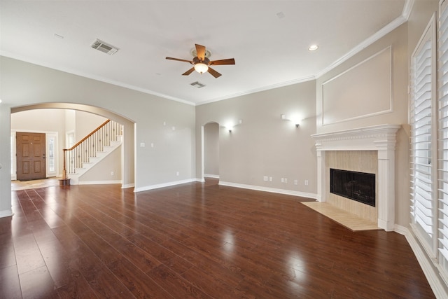 unfurnished living room featuring ornamental molding, ceiling fan, a tile fireplace, and dark hardwood / wood-style flooring