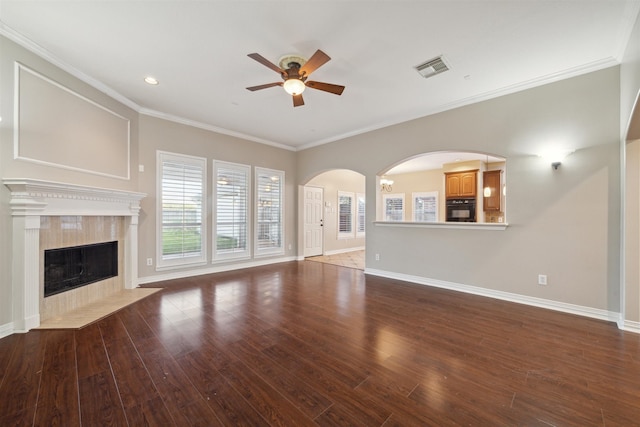 unfurnished living room with a high end fireplace, ornamental molding, dark hardwood / wood-style floors, and ceiling fan