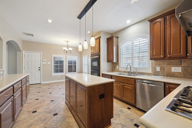 kitchen featuring sink, a center island, stainless steel appliances, pendant lighting, and decorative backsplash