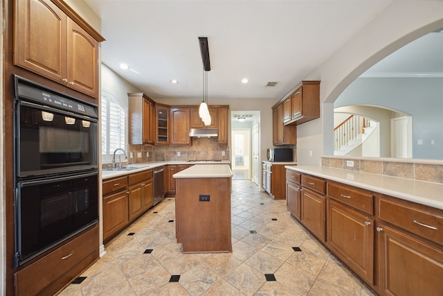 kitchen with a kitchen island, sink, crown molding, appliances with stainless steel finishes, and tasteful backsplash