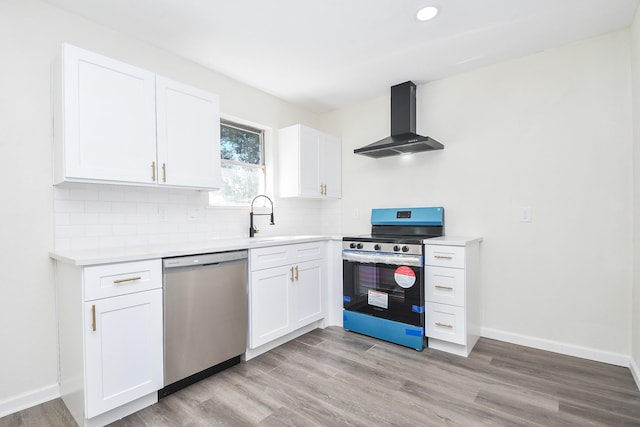 kitchen featuring white cabinetry, appliances with stainless steel finishes, wall chimney exhaust hood, and tasteful backsplash