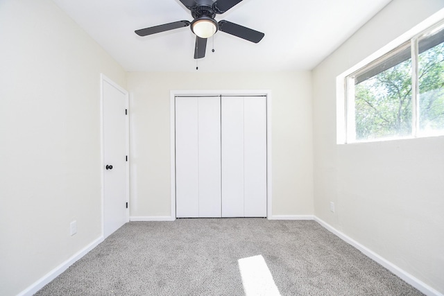 unfurnished bedroom with light colored carpet, ceiling fan, and a closet