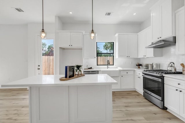 kitchen featuring pendant lighting, white cabinets, sink, appliances with stainless steel finishes, and a kitchen island