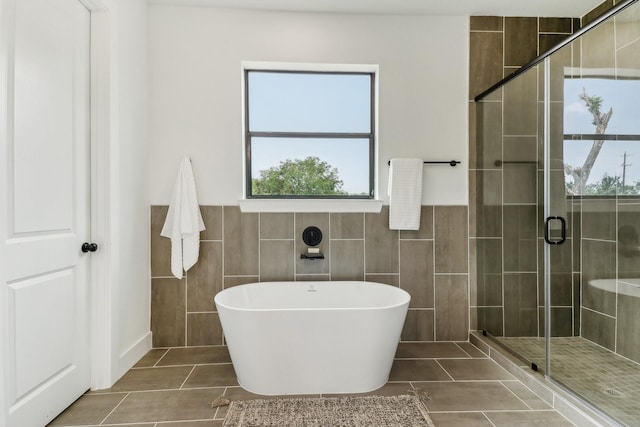 bathroom featuring tile patterned flooring, tile walls, and independent shower and bath