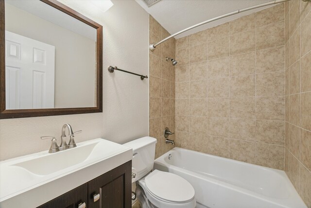 full bathroom with vanity, tiled shower / bath, and toilet