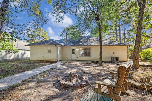 rear view of property with a fire pit