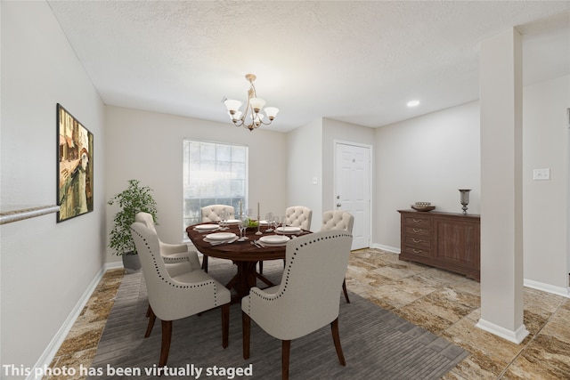 dining area featuring an inviting chandelier and a textured ceiling