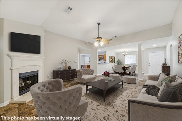 living room featuring ceiling fan with notable chandelier