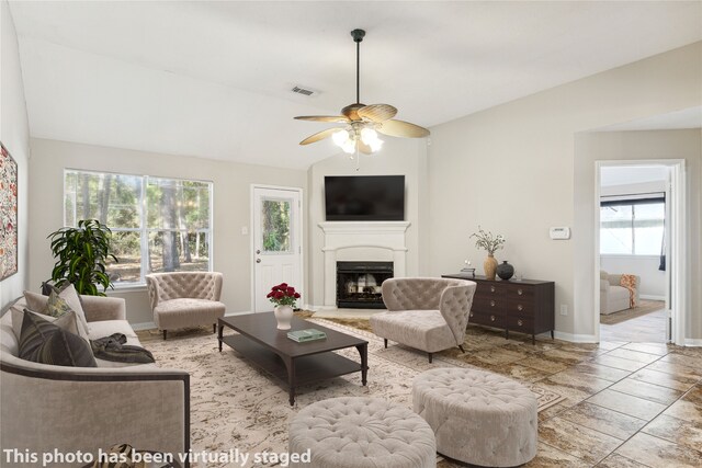 living room with a wealth of natural light, lofted ceiling, and ceiling fan