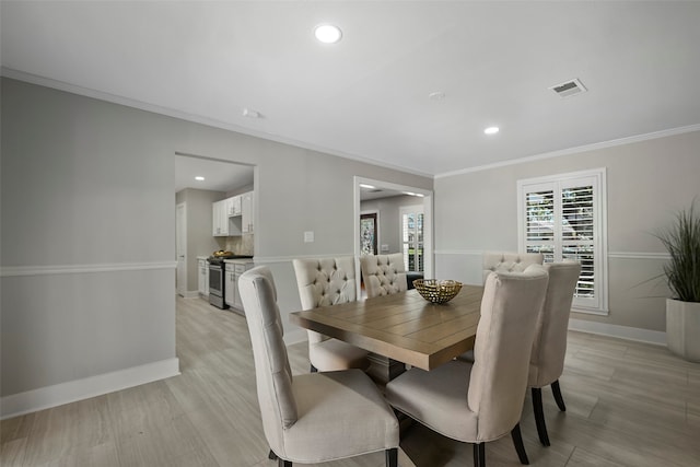 dining space featuring crown molding and light hardwood / wood-style floors