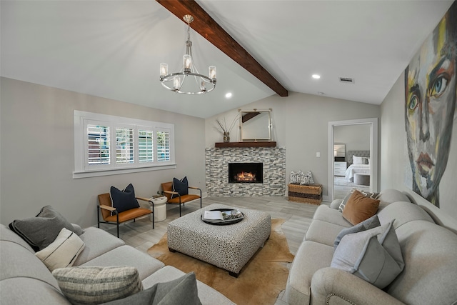 living room with an inviting chandelier, lofted ceiling with beams, a tiled fireplace, and light hardwood / wood-style floors