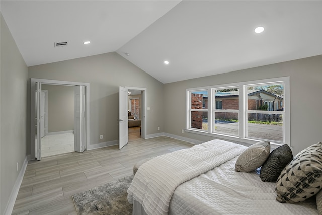 bedroom with light hardwood / wood-style floors and lofted ceiling