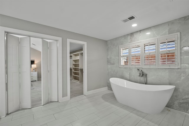 bathroom featuring tile walls and a bathing tub