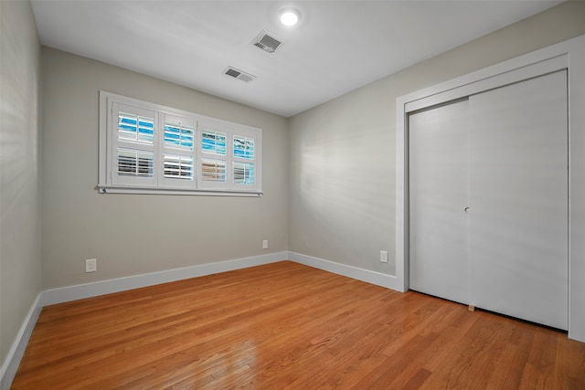 unfurnished bedroom with a closet and light wood-type flooring