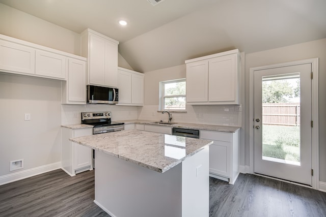 kitchen featuring vaulted ceiling, a center island, stainless steel appliances, and white cabinets