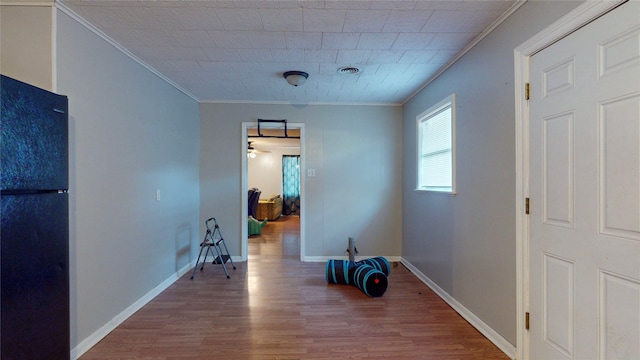 interior space with ornamental molding and wood-type flooring