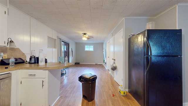 kitchen featuring black fridge, ornamental molding, white cabinets, light hardwood / wood-style floors, and ceiling fan