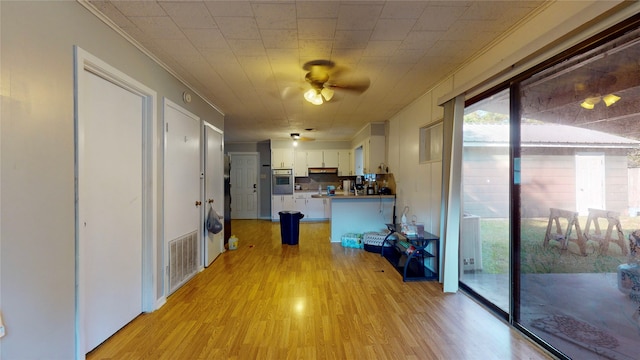 hall with light hardwood / wood-style floors and crown molding