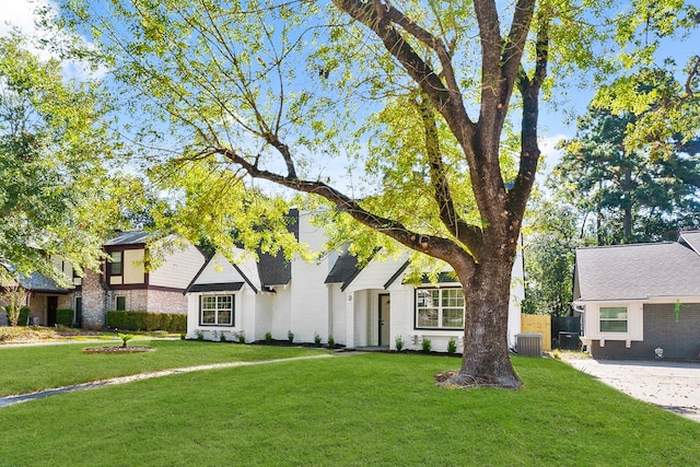 view of front of home featuring a front lawn and central AC