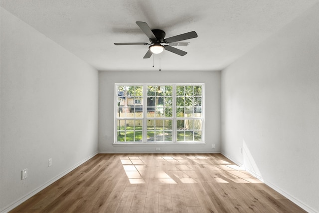 spare room featuring ceiling fan, a textured ceiling, and light wood-type flooring