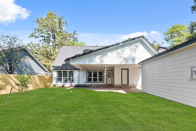 rear view of property with a yard