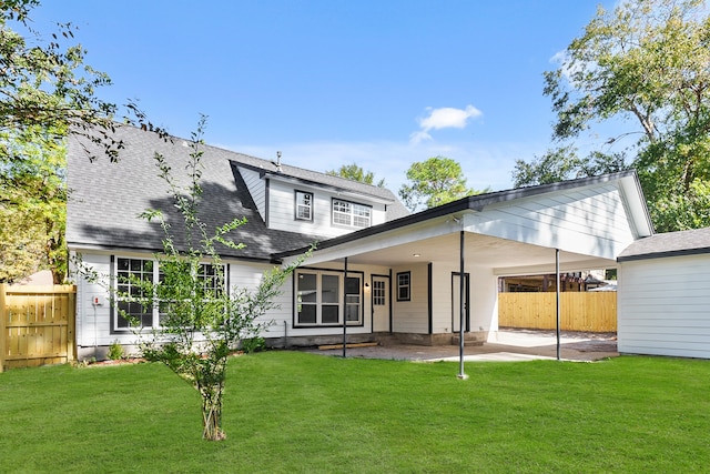 back of property featuring a lawn and a carport