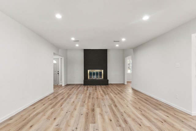 unfurnished living room featuring light hardwood / wood-style flooring and a fireplace