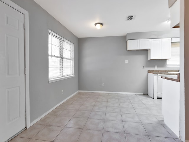 unfurnished dining area featuring light tile patterned floors