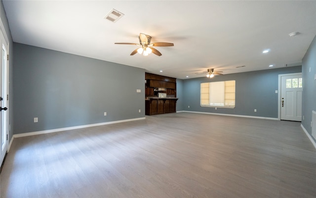 unfurnished living room with ceiling fan and hardwood / wood-style floors