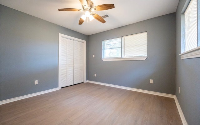 unfurnished bedroom with a closet, ceiling fan, and hardwood / wood-style floors