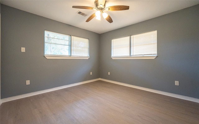 empty room with ceiling fan and hardwood / wood-style flooring