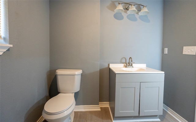 bathroom featuring toilet, hardwood / wood-style floors, and vanity