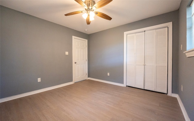 unfurnished bedroom featuring light hardwood / wood-style flooring, a closet, and ceiling fan