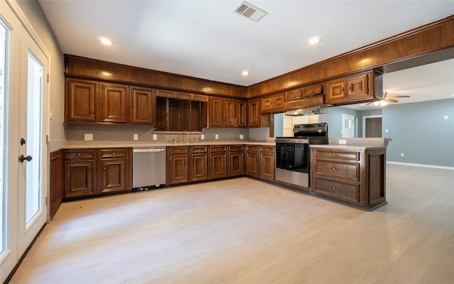 kitchen featuring kitchen peninsula, exhaust hood, ceiling fan, sink, and stainless steel appliances