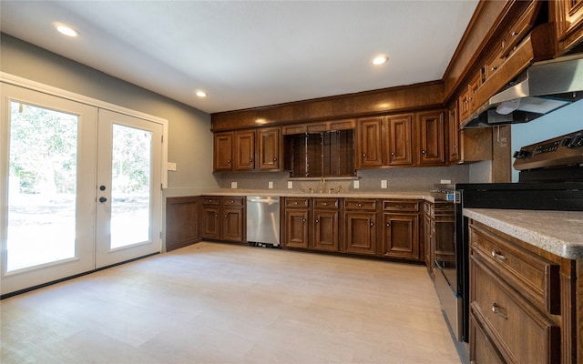 kitchen featuring appliances with stainless steel finishes, french doors, premium range hood, and backsplash