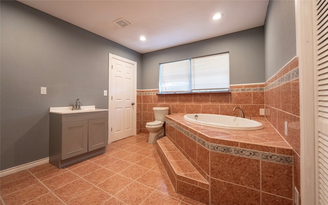 bathroom featuring vanity, toilet, a relaxing tiled tub, and tile patterned floors