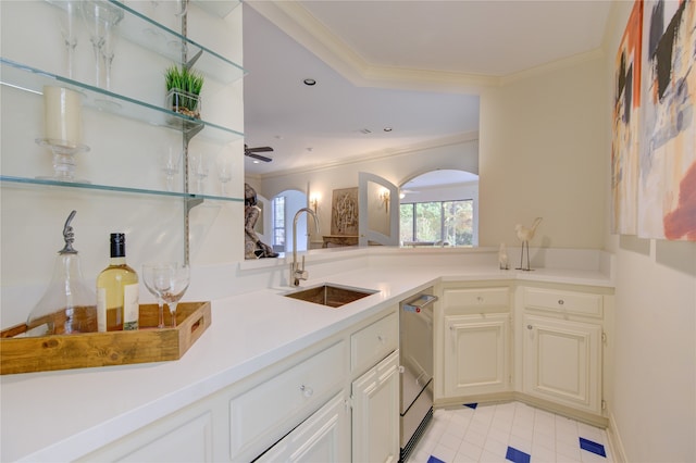 kitchen with dishwasher, kitchen peninsula, sink, ceiling fan, and crown molding