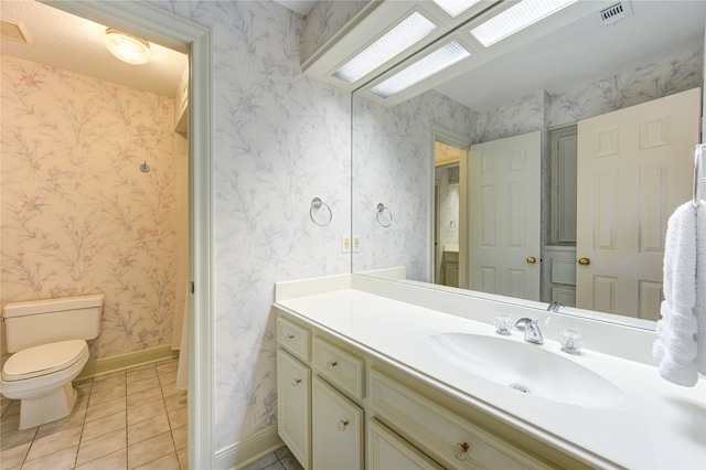 bathroom with vanity, tile patterned floors, and toilet