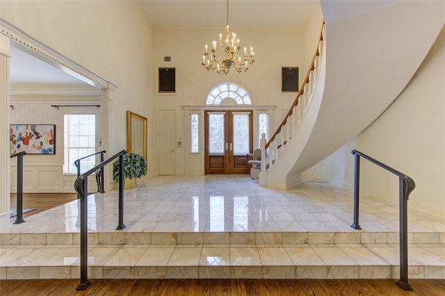 entryway featuring an inviting chandelier, french doors, ornamental molding, and wood-type flooring