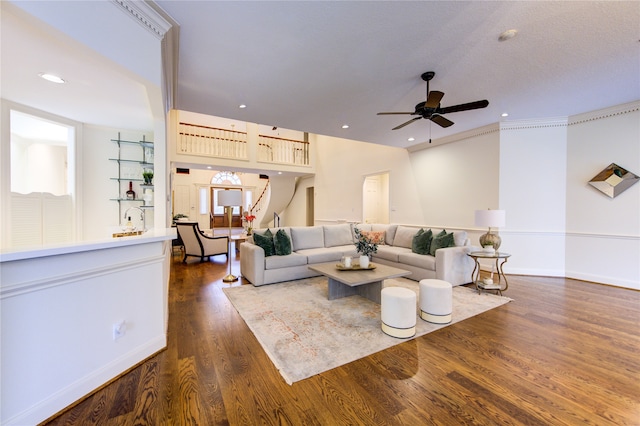 living room with ornamental molding, a healthy amount of sunlight, dark hardwood / wood-style flooring, and ceiling fan