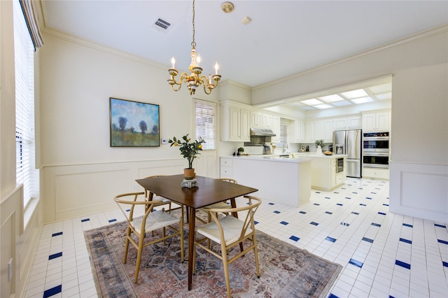 dining room with a chandelier, light tile patterned floors, and crown molding