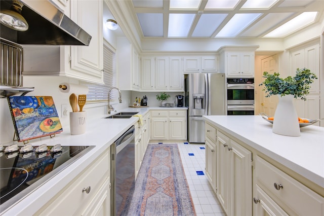 kitchen featuring appliances with stainless steel finishes, sink, exhaust hood, and white cabinets