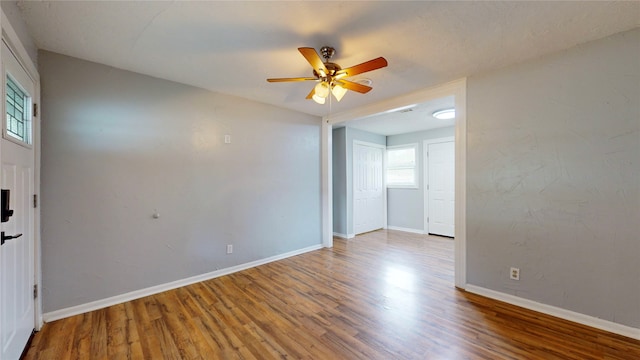 spare room with a wealth of natural light, hardwood / wood-style floors, and ceiling fan