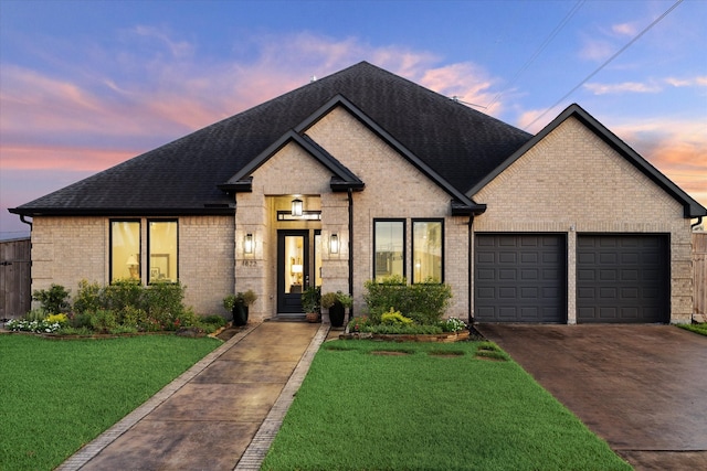 view of front facade with a yard and a garage