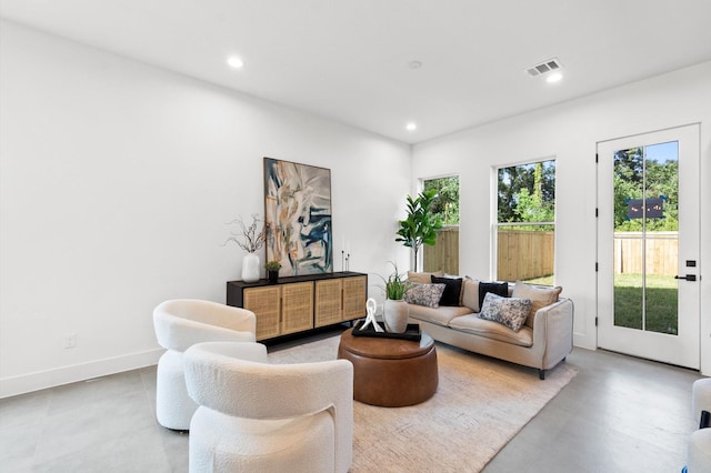 living area featuring baseboards, visible vents, and recessed lighting