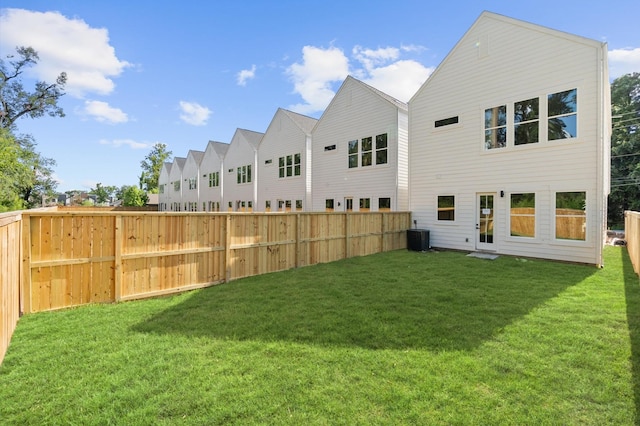 exterior space featuring central air condition unit, a lawn, and fence