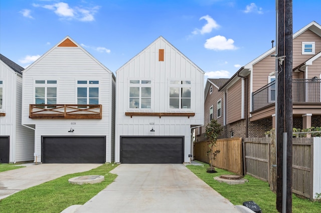 view of front facade with board and batten siding, fence, driveway, and an attached garage