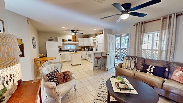 tiled living room featuring ceiling fan and sink