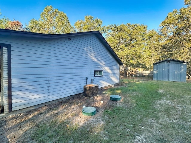 view of property exterior featuring a shed, central AC unit, and a yard