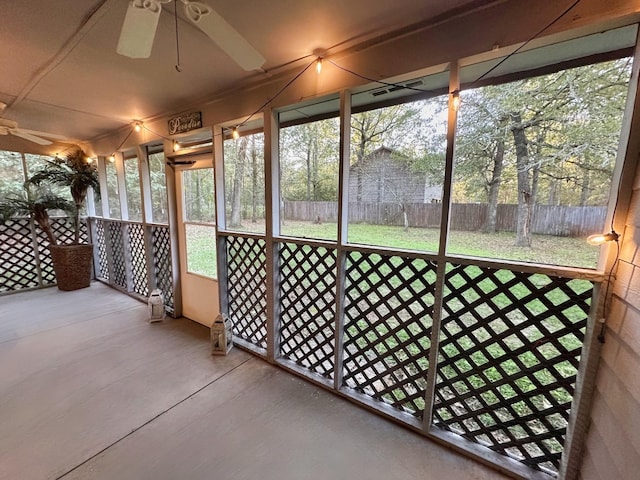 unfurnished sunroom with ceiling fan